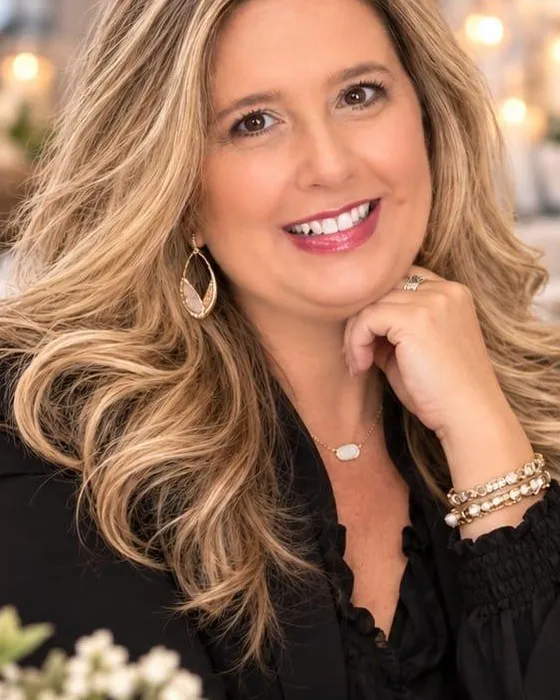 Portrait of Tammy, the owner of Oak & Lace Events + Decor, smiling with her hand under her chin